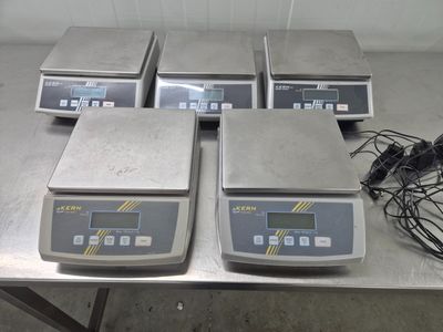 quatre balances électroniques posées sur une table dans une pièce