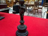 a statue of a child on a pedestal on a red carpet