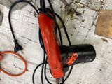 a red blow dryer and a pair of scissors on a table