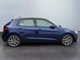 the rear end of a blue car parked in a parking lot
