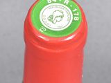 a close up of a bottle of wine with a red cap