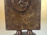 statue of a man with a face on a wooden base