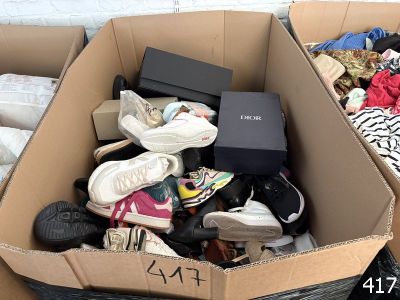 plusieurs paires de chaussures dans une boîte en carton posée sur le sol