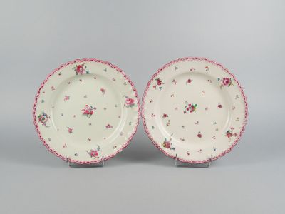 une paire d'assiettes roses et blanches ornées de motifs floraux