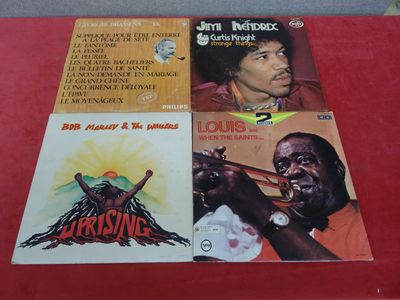 Trois vinyles de reggae de différents styles sont posés sur une table rouge