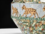 a vase with a picture of giraffes on it on a table