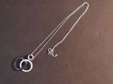 a close up of a silver necklace with a circle on it
