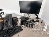 un bureau sur lequel se trouvent un ordinateur, un clavier, une souris et d'autres appareils électroniques