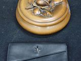 un sac à main noir et un plateau doré orné d'une rose