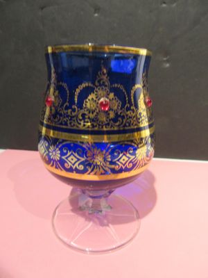 a blue and gold vase sitting on a pink table