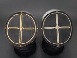 two black and gold ear plugs with crosses on them