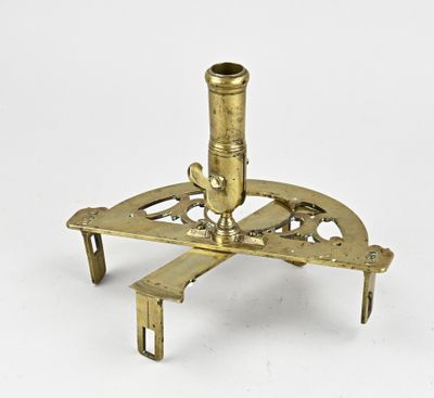 un microscope ancien plaqué laiton posé sur un support, sur fond blanc