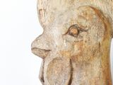 a wooden sculpture of a rooster on a white surface