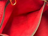 the inside of a red and black purse with a gold handle