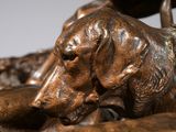 bronze statue of a woman and a dog on a rock