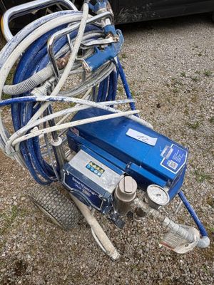 an image of a blue air compressor with hoses attached to it