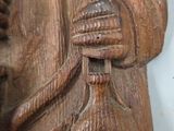 a wooden sculpture of a man with a hat and a cane