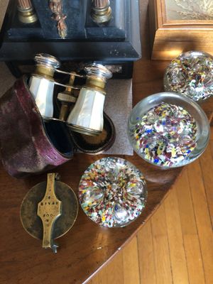 une table sur laquelle se trouvent une horloge, une paire de jumelles et d'autres objets