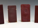 four pieces of red and brown leather are lined up in a row