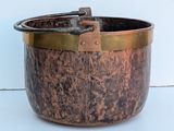 a large metal pot with a handle on a table