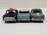 three toy cars are lined up in a row on a white surface