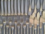a lot of forks and spoons that are on the table