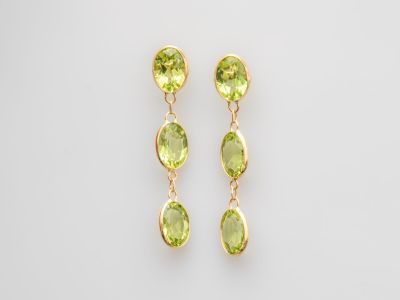 une paire de boucles d'oreilles en péridot vert sur fond blanc
