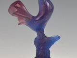 a glass sculpture of a bird perched on a tree branch