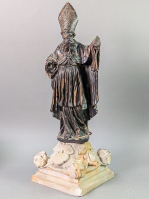 statue of a man with a hat and a robe on a pedestal