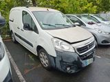 une camionnette blanche qui a été fortement endommagée dans un parking