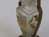 a glass vase on a wooden stand on a white surface