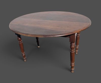 une vieille table en bois aux pieds tournés et au plateau rond