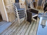 des tables et des chaises sur une terrasse en bois à l'extérieur d'un bâtiment