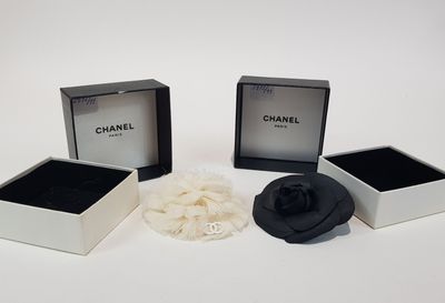 three black and white jewelry boxes with a flower in them