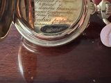 une personne tenant une montre de poche en or posée sur une table