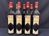 quatre bouteilles de vin sont alignées sur une surface noire