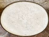 a large round pizza sitting on top of a brick floor