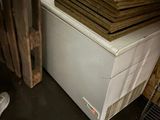a man that is standing next to a stack of wood