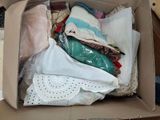 a cardboard box filled with clothes and a pair of scissors