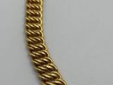 a gold necklace with a twisted design on a white background