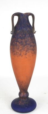 a blue and orange vase sitting on a white surface