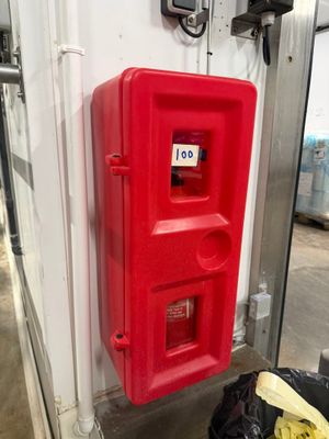 une borne d'incendie rouge adossée à un mur