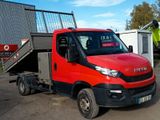 un camion rouge et noir garé devant un immeuble