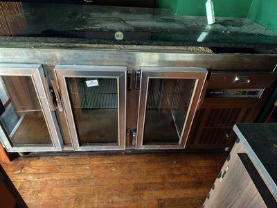 une photo d'une cuisine équipée d'appareils électroménagers en inox et dotée d'un parquet