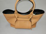 sac à main en cuir beige avec des anses noires sur fond blanc