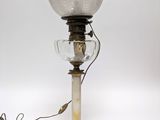 an old fashioned lamp with a glass shade on top of it