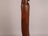 carved wooden statue of a woman holding a bird on her shoulder