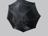 a black umbrella that is open on a gray background