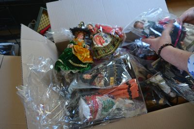 une personne tenant une boîte remplie de jouets assortis