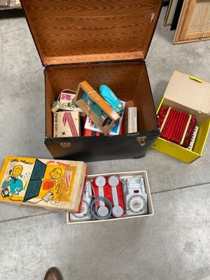 une valise remplie de fournitures scolaires posée par terre